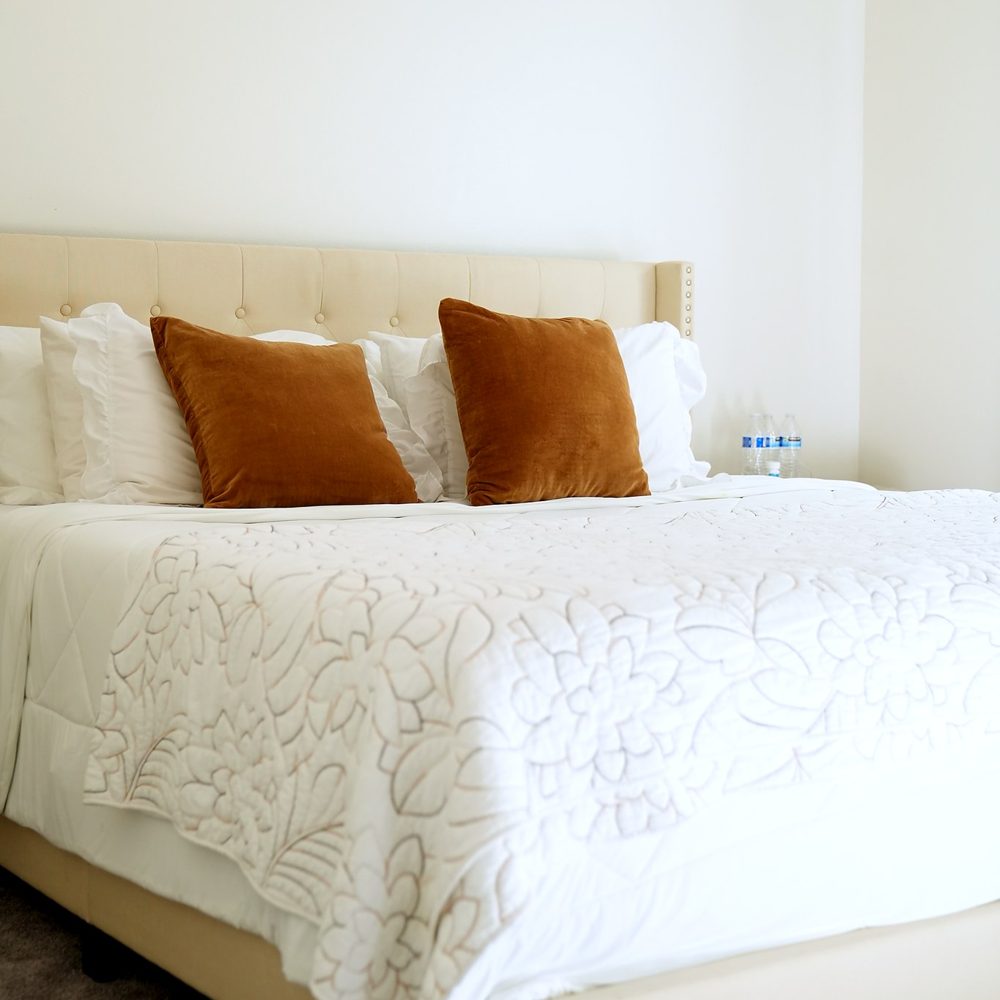 A bedroom after a visit, with the bed made